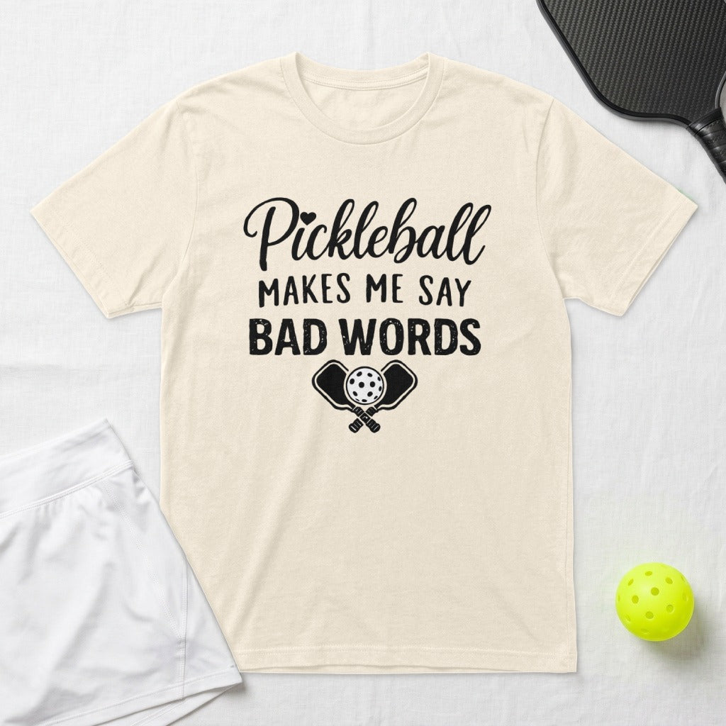 Cream t-shirt with "Pickleball Makes Me Say Bad Words" graphic and crossed paddles.
