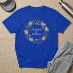 Blue t-shirt with a floral wreath design and text "Pickleball & Prosecco".