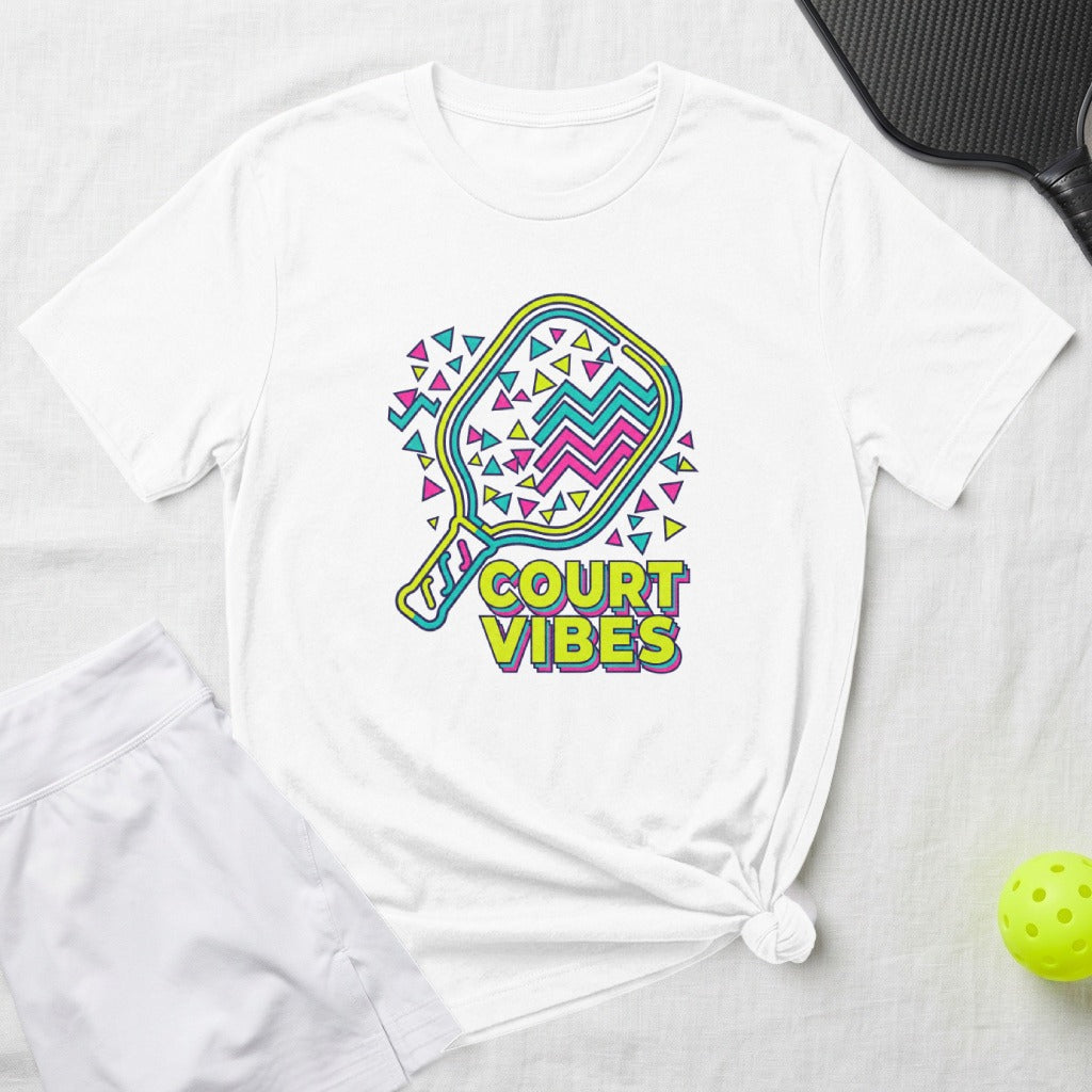 White t-shirt with "COURT VIBES" and a colorful pickleball paddle graphic.