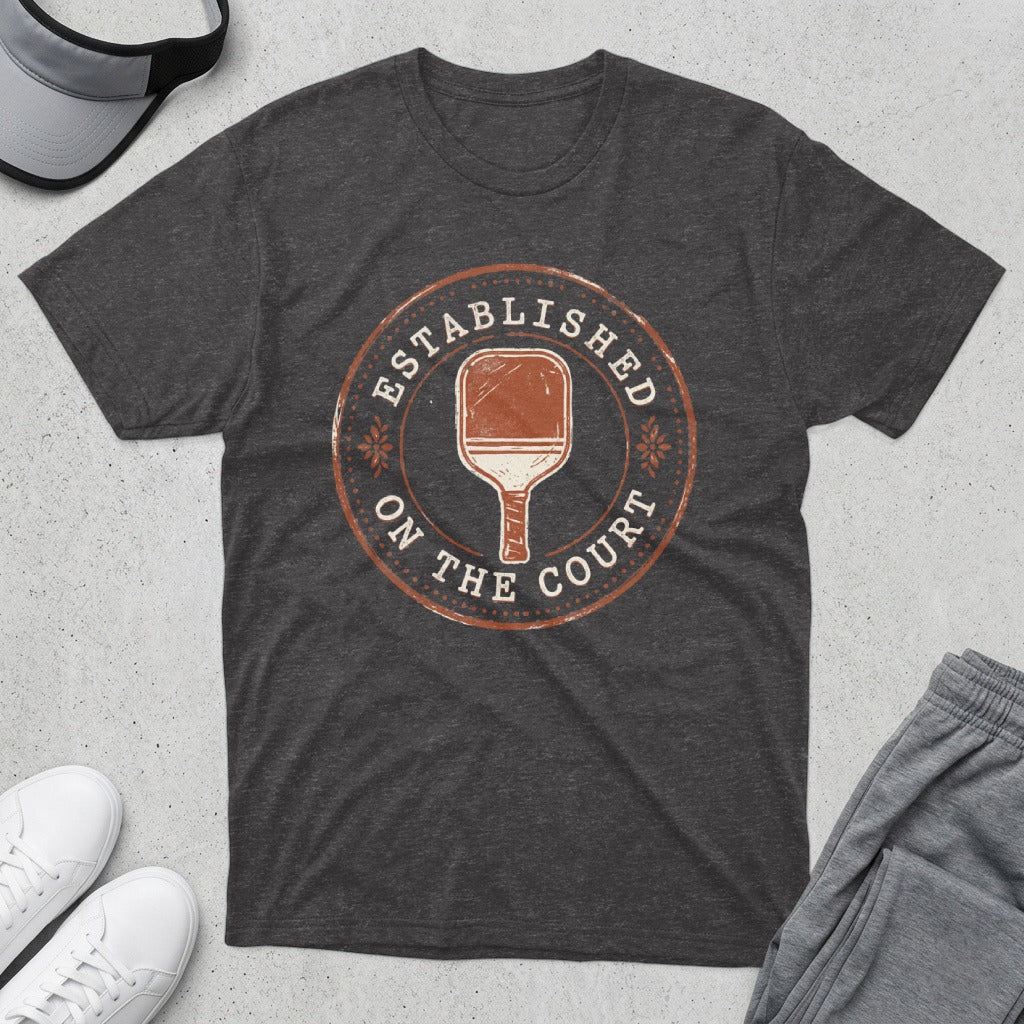 T-shirt with a distressed round graphic of a pickleball paddle and "Established on the Court."