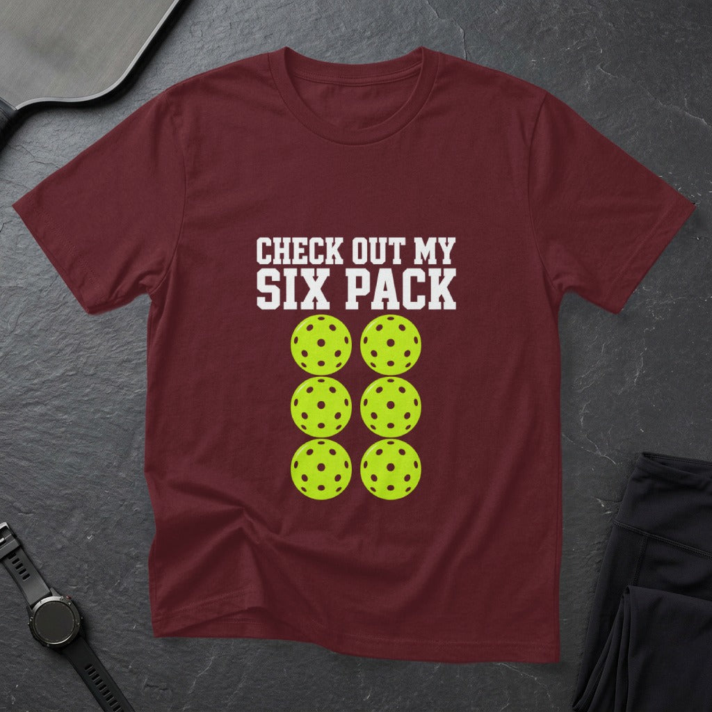 Maroon t-shirt with six lime green pickleballs and "CHECK OUT MY SIX PACK" text.