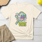 Cream t-shirt with "Court Vibes" text and colorful pickleball graphic.