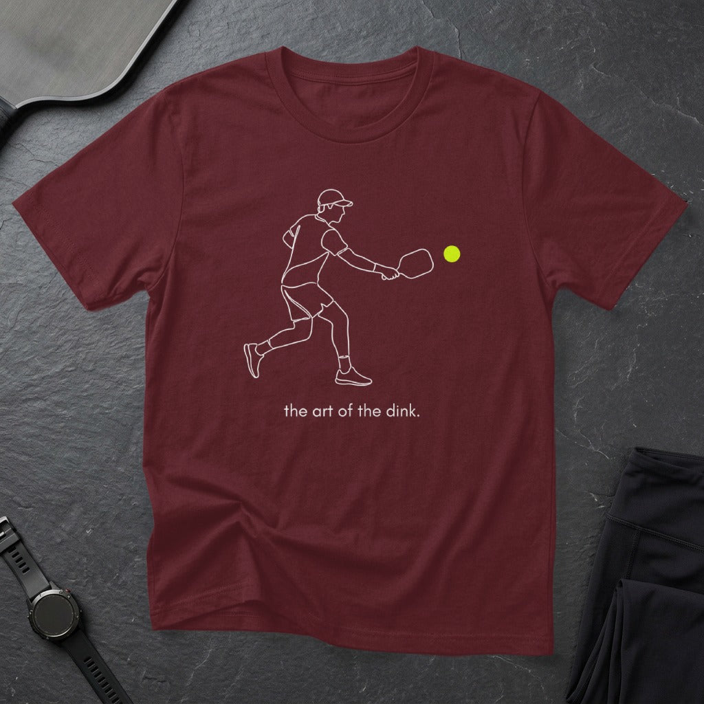 Maroon t-shirt with a line drawing of a pickleball player and text "the art of the dink."