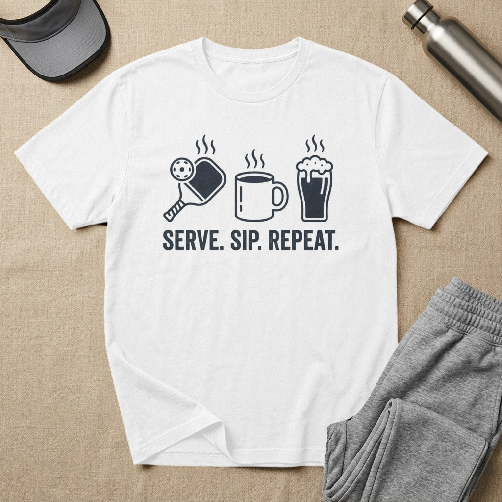 White t-shirt with pickleball, coffee cup, and beer mug icons and text "SERVE. SIP. REPEAT."