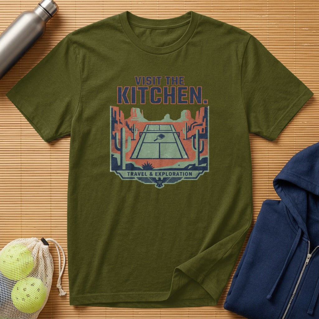 Olive green t-shirt with "VISIT THE KITCHEN. TRAVEL & EXPLORATION" graphic.