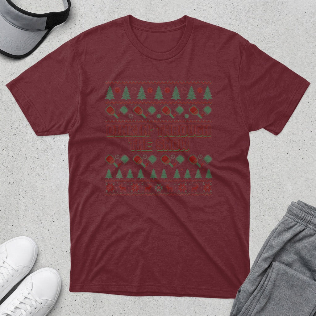 Maroon t-shirt with "Pickleball Through the Snow" text and holiday-themed pickleball graphics.